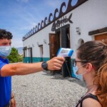 Una turista antes de entrar en un restaurante en una playa de Granada en estado de alerta por el coronavirus.
