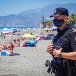 Un policía nacional vigila un playa en Granada en estado de alerta por el coronavirus.